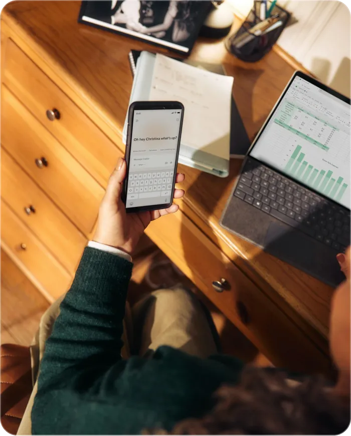 phone in hand at the desk